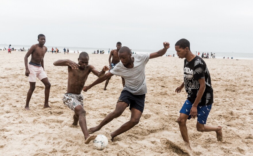 Beachgoers play soccer in Durban, South Africa, during the omicron surge in December 2021.