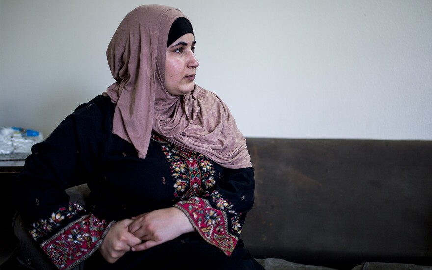 Mostafa Inezan's wife, Waelah, sits on a couch in her family's new three-bedroom apartment, July 25, 2017.