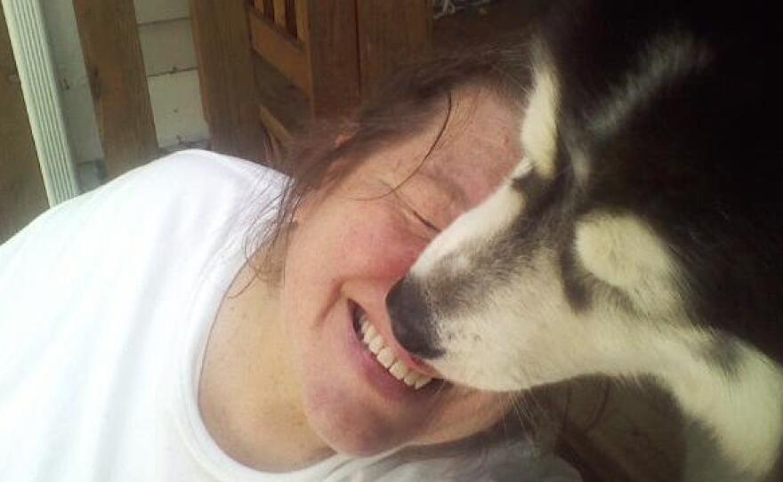 Beverly Pickering goofs around with client Bella the husky. Pickering's dog walking and pet sitting business relies on people traveling. People aren't doing that much these days.