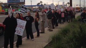 People with Sweetwater Education Association hold signs and rally in Chula Vista on March 21, 2014.