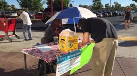 Outside a Target in Clairemont, a man signs a petition in support of putting on the ballot an initiative designed to boost downtown San Diego tourism and redevelop the Qualcomm Stadium property in Mission Valley, Nov. 21, 2015.