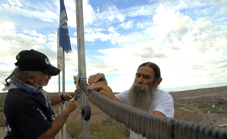 Vietnam veterans Oscar Urrea and Steve Guzzo inspect some of the more than 2,000 replica dog tags on the Mares Bluff Veterans Memorial in Clifton, Ariz. 