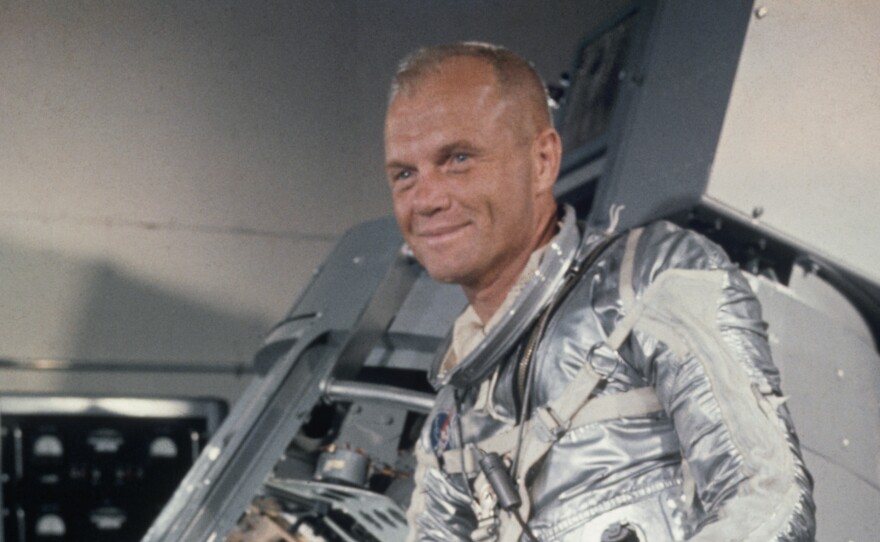 John Glenn stands beside a Mercury capsule during training at Cape Canaveral, Fla., in 1962.