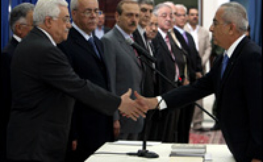 Newly-appointed prime minister Salam Fayyad (R) shakes hands with Palestinian President Mahmud Abbas (L) during the swearing in ceremony of the new emergency cabinet in the West Bank city of Ramallah, June 17, 2007.