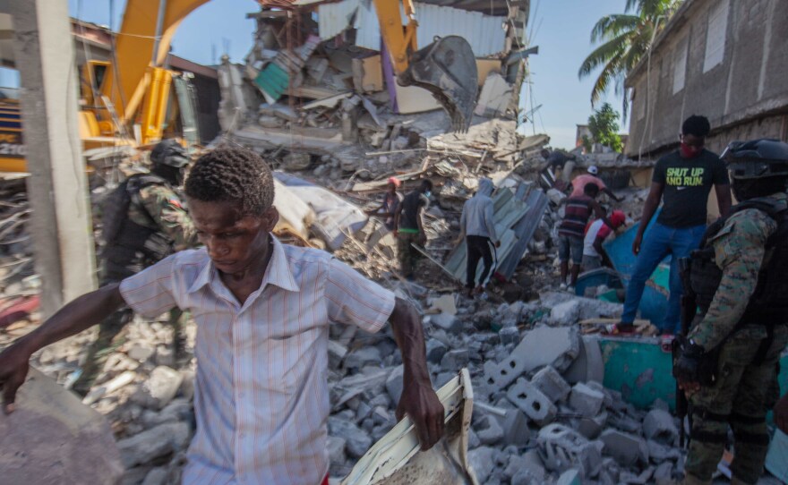 Haitians in Les Cayes assess the damage on Sunday after a 7.2-magnitude earthquake struck Haiti.