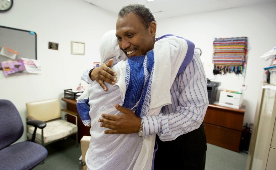 Shekhey hugs Loba Tebemo Godiso after helping her and a friend at the Somali American Community Center. Many of the refugees Shekhey helps have spent years, even decades, in refugee camps before coming to the U.S.