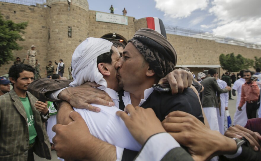A Yemeni detainee (left) is greeted by a family member after being released by Houthi rebels on Monday. The release was brokered by the International Committee of the Red Cross.