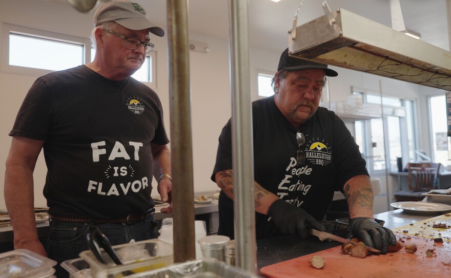 Blake Barrow works with an employee at Hallelujah! BBQ.