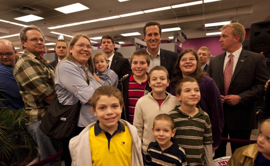 Rick Santorum poses with people at Harvest Graphics, a small business, during a campaign stop Wedneday in Lenexa, Kansas. 