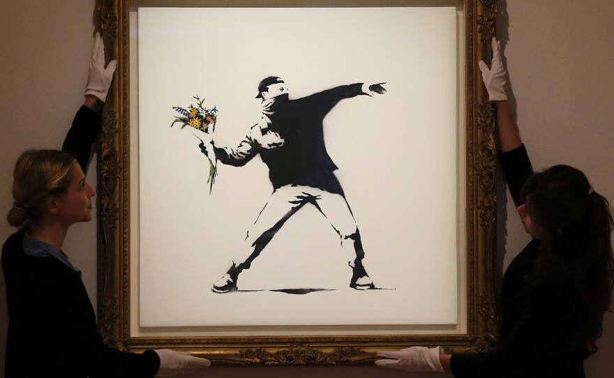 A limited edition of Banksy's "Love Is in the Air" sold for $249,000 at Bonhams auction house in London this summer. The artist offeed a version of the work for $60 on the sidewalk in New York Saturday.