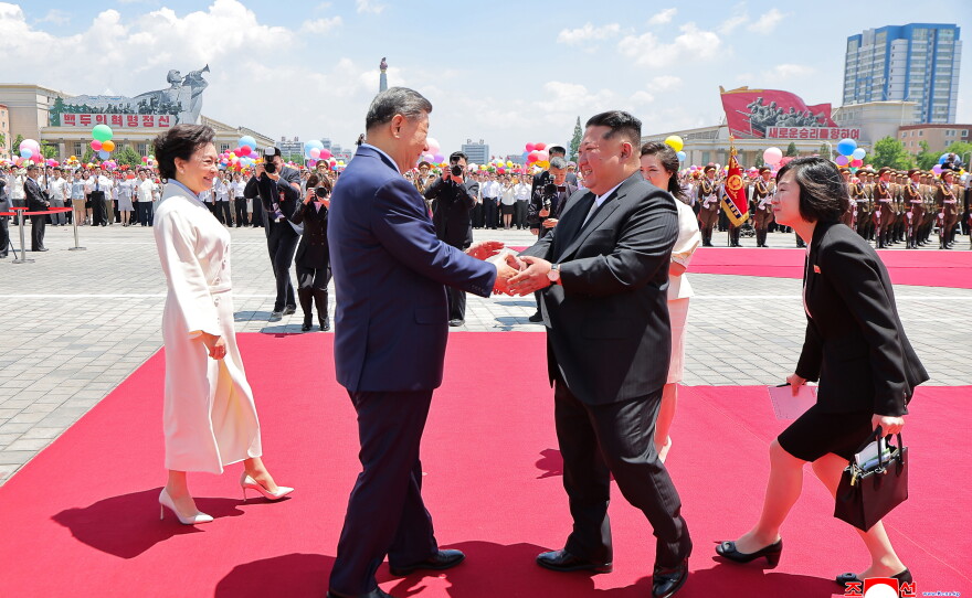 In this photo provided by the North Korean government, Chinese President Xi Jinping (center left) shakes hands with North Korean leader Kim Jong Un (center right) during a welcome ceremony in Pyongyang on Monday.