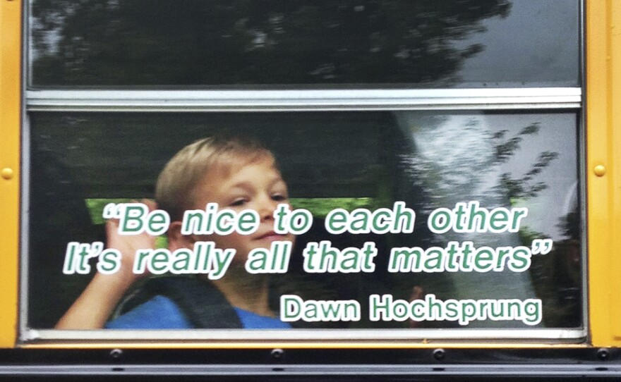 Voters in Newtown, Conn., have approved a plan to use nearly $50 million in state funds to demolish Sandy Hook Elementary and build a new school in its place. This photo provided by Craig Hoekenga shows his son Trey, a kindergarten student at Sandy Hook, on the school bus this year. The window has a quote from the late principal, Dawn Hochsprung, who was killed in last December's mass shooting.