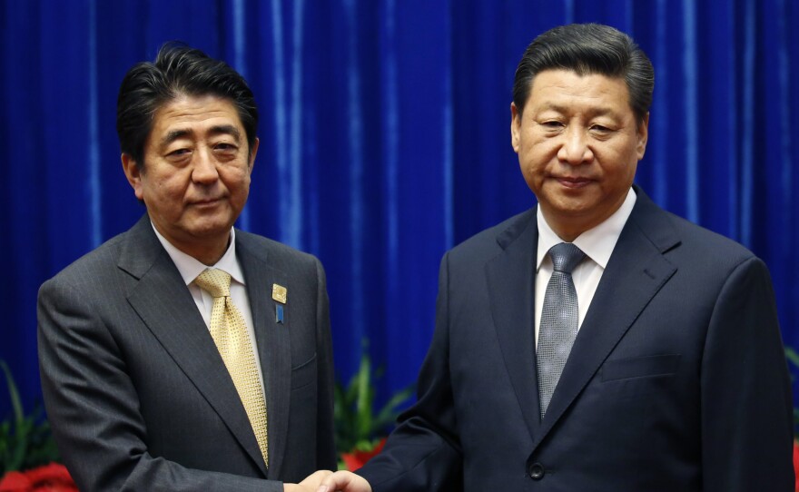Japan's Prime Minister Shinzo Abe, left, and China's President Xi Jinping, right, shake hands during their meeting at the Great Hall of the People, on the sidelines of the Asia-Pacific Economic Cooperation (APEC) summit in November.