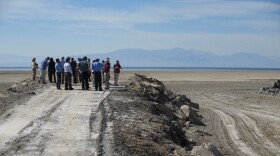State lawmakers and state agency representatives look at an area that once was covered by water from the Salton Sea, March 16, 2017. The sea in the distance.