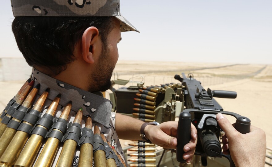 A member of the Saudi border guards force mans a machine gun at Saudi Arabia's northern border with Iraq, on July 14. Since the so-called Islamic State launched its offensive this summer in Iraq, Saudi Arabia has sent thousands of troops to the border area.