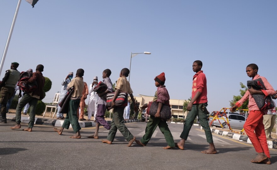 Released students from the Government Science Secondary school in Kankara, in Nigeria's northwestern Katsina State, are led into the Government House upon their release on Friday.
