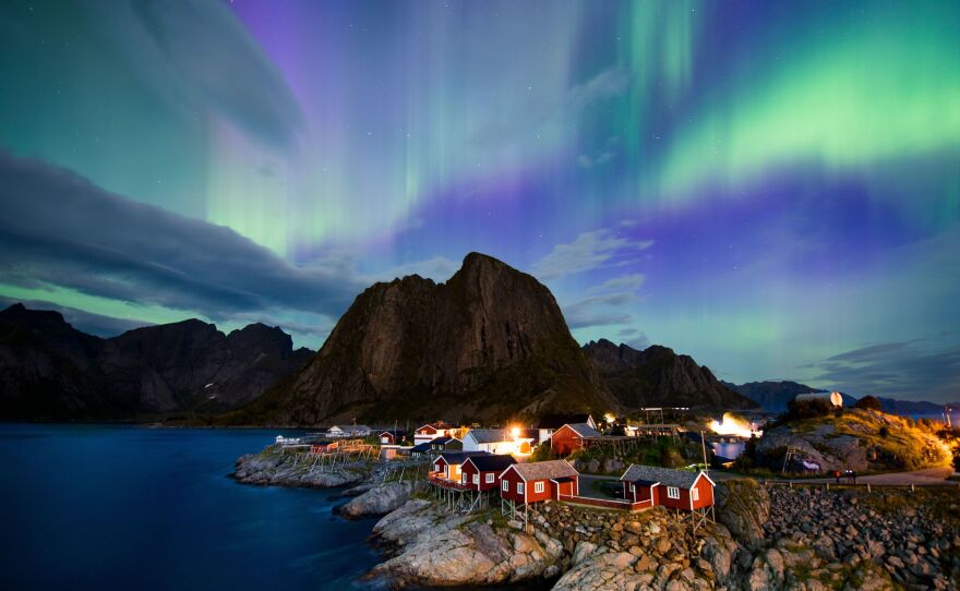 Northern lights (aurora borealis) illuminate the sky over Reinfjorden in Reine, on Lofoten Islands, Arctic Circle, on September 8, 2017.