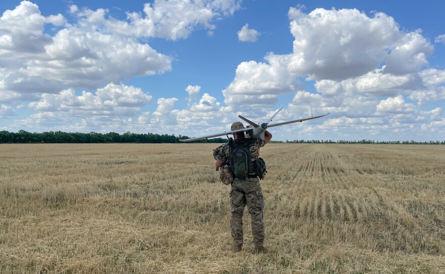 A member of a Ukrainian military surveillance team gets ready to launch a drone from a wheat field in southern Ukraine.