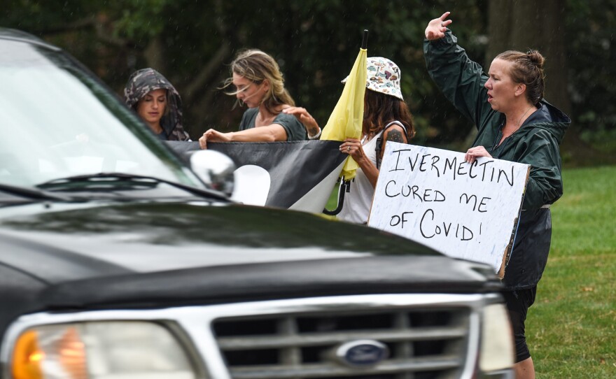 Protesters for an anti-vaccine rally in Cincinnati in August carry a sign backing ivermectin. Belief in the drug's efficacy often goes hand in hand with vaccine hesitancy.