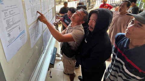 People check the passenger manifest of Virgo Transport 8 passenger ferry which overturned in bad weather in the Java Sea, at the rescuers' command center in Banjarmasin, South Kalimantan, Indonesia, Monday, Sept. 14, 2026.