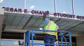 A worker removing César Chávez' name off the student services building at Southwestern College on March 19, 2026.