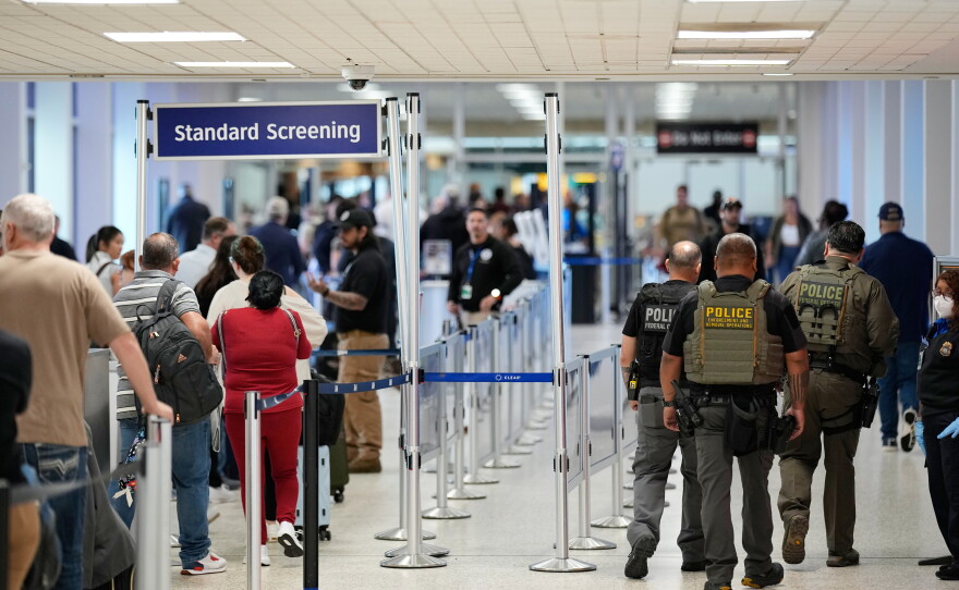 Federal immigration officers walk through a security checkpoint at George Bush Intercontinental Airport in Houston in March.