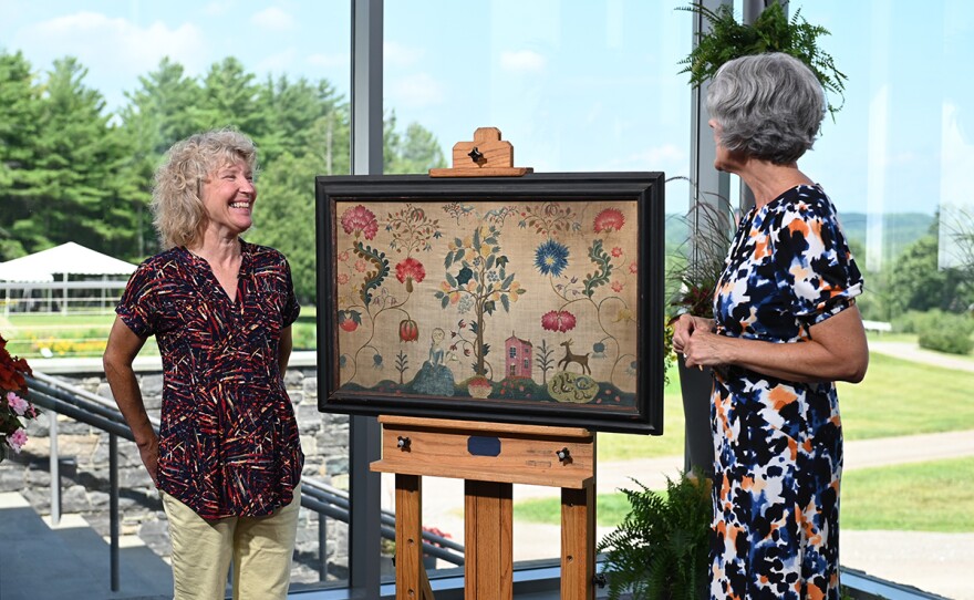 Deborah Miller (right) appraises a schoolgirl needlework, ca. 1740, in Shelburne, Vt.