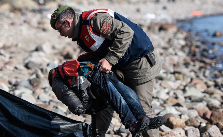 A Turkish gendarme carries the body of a child on a beach in Canakkale, Turkey, on Saturday.