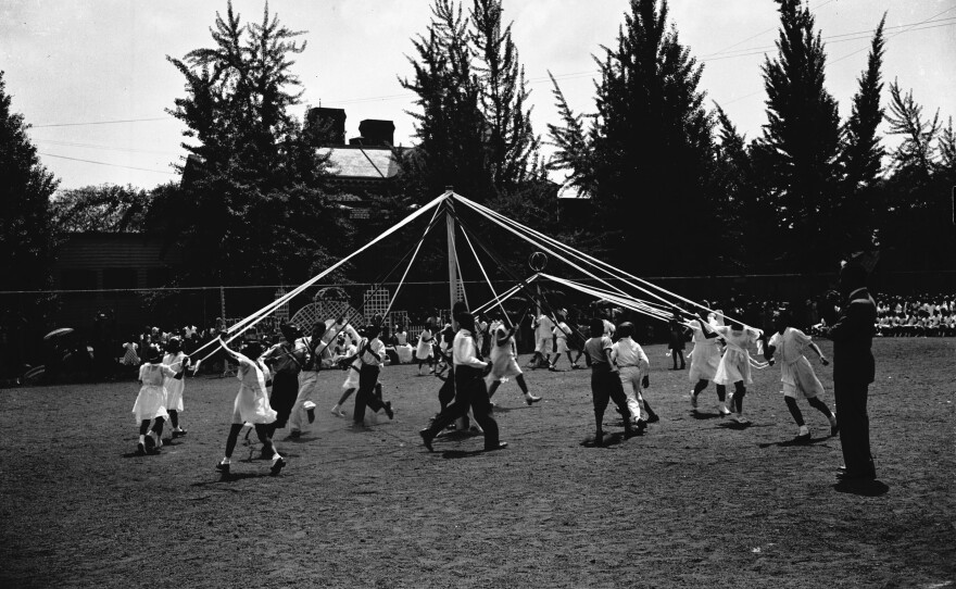 Children dancing around a maypole.