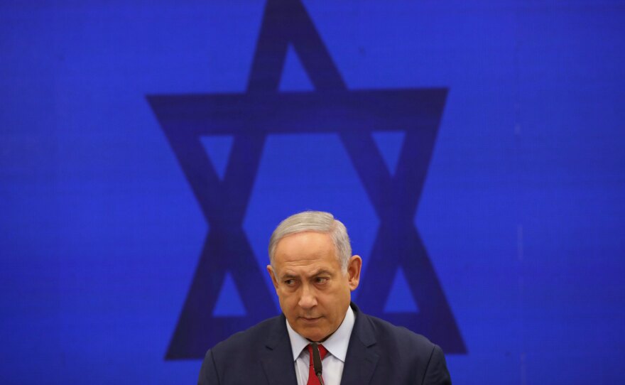 Israeli Prime Minister Benjamin Netanyahu speaks during a news conference in Tel Aviv last September. Netanyahu, the country's longest-serving prime minister, will go to court on Sunday charged with bribery, fraud and breach of trust.