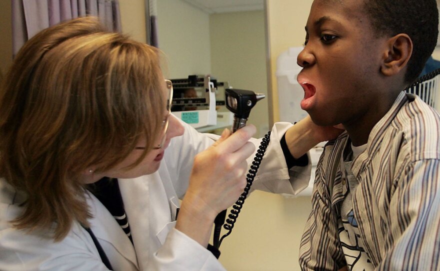 A doctor examines patient Michelo Cineas at the Codman Square Health Center in Dorchester, Massachusetts.