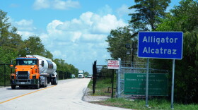 FILE - Trucks come and go from the "Alligator Alcatraz" immigration detention center in the Florida Everglades, Aug. 28, 2025, in Collier County, Fla.