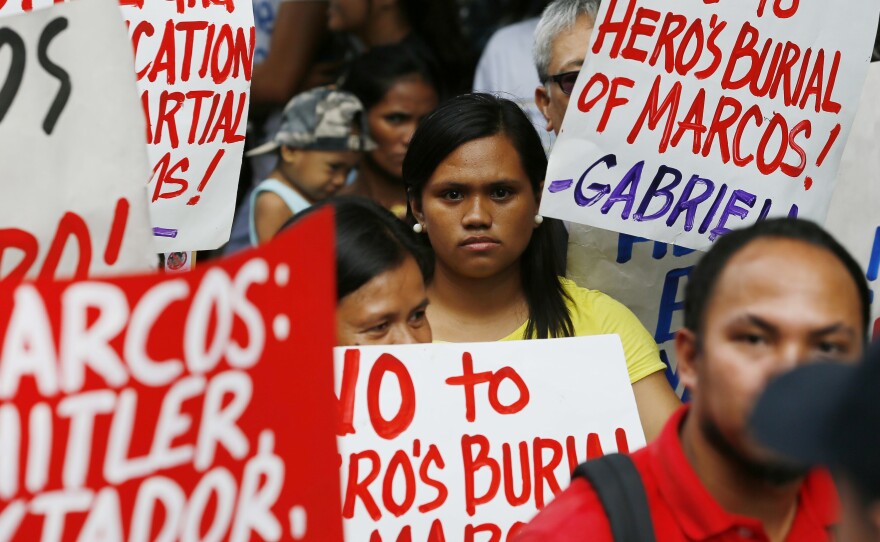 Protesters listen to the ruling of the Philippine Supreme Court allowing the body of late Philippine dictator Ferdinand Marcos to be buried at the country's Heroes' Cemetery.