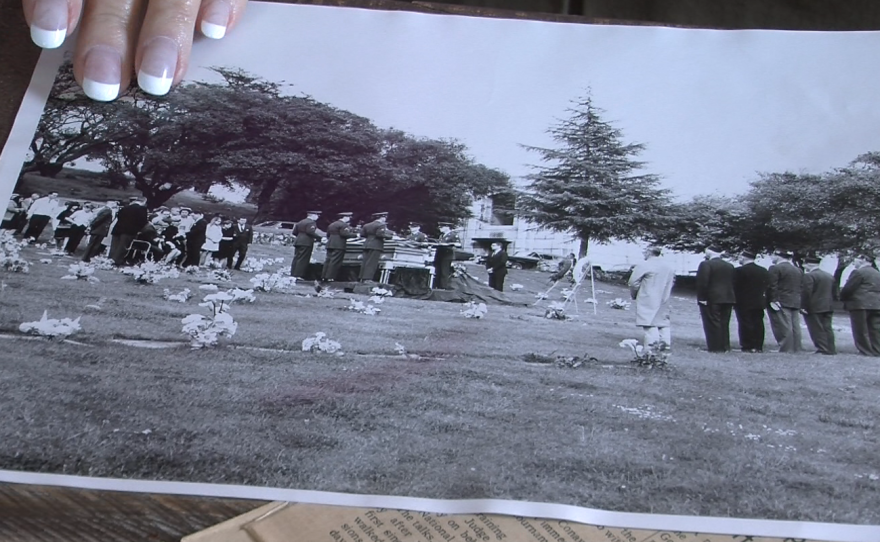 Patty Lee places her hand on a black and white photo of the funeral for her father, Delbert C. Totty, an Army master sergeant who was killed in the Vietnam War in 1967. 