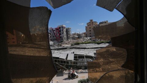 Buildings damaged by Israeli strikes are seen through shattered glass from the Jabal Amel Hospital in the southern port city of Tyre, Lebanon, Thursday, June 18, 2026.