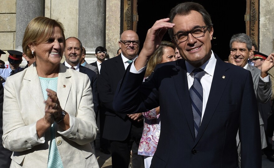 President of Catalonia's regional government Artur Mas acknowledges cheers Saturday after signing a law setting a Nov. 9 vote on independence. At left is the president of the Catalan Parliament, Nuria de Gispert.