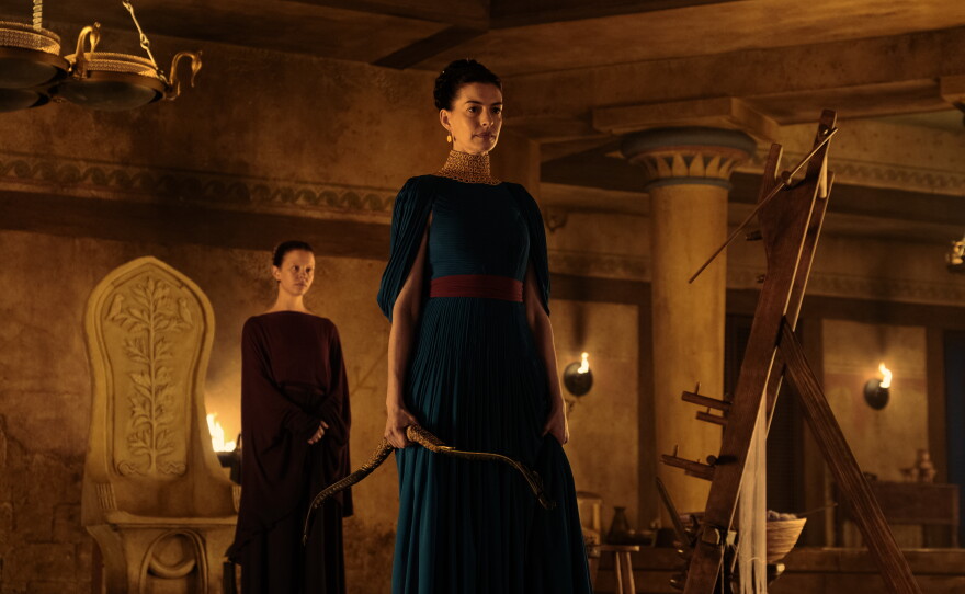 Mia Goth as Melantho and Anne Hathaway as Penelope.