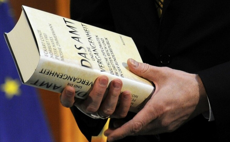 German Foreign Minister Guido Westerwelle holds the report at its release Thursday. He said the extent of ministry collusion during the Nazi era "shames us."