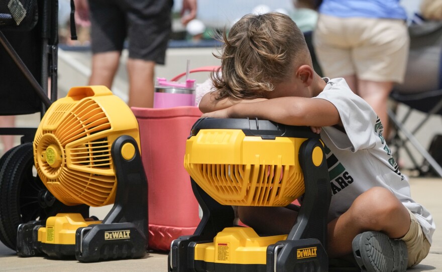 Braxton Hicks, 7, of Livingston, Texas, holds his face to a portable fan to cool off during a Little League tournament in Ruston, La., last week. More very hot weather is expected this weekend in much of the central U.S.