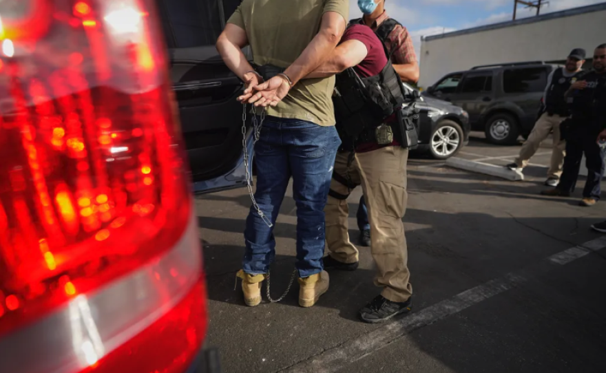 Agentes del Servicio de Inmigración y Control de Aduanas de Estados Unidos trasladan a un inmigrante después de una redada en la madrugada en Duarte el 6 de junio de 2022. Foto de Damian Dovarganes, AP Photo