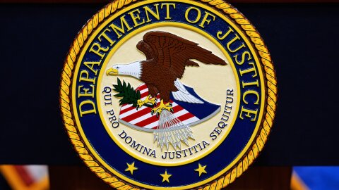 The U.S. Department of Justice logo is seen on a podium before a news conference at the Justice Department in Washington, on May 6, 2025.