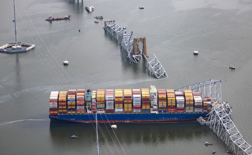 In an aerial view, the cargo ship Dali sits in the water after running into and collapsing the Francis Scott Key Bridge in Baltimore on Tuesday.