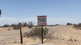 A sign near the MV-22B Osprey crash site in Glamis, California, reads "Danger. Military Training In Progres. Do Not Enter," June 8, 2022.