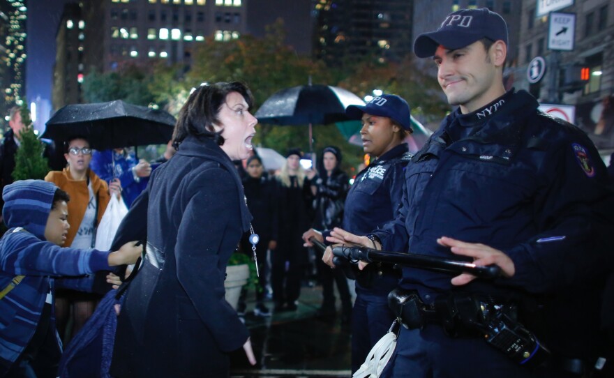 A woman argues with NYPD officers as she takes part in a protest against President-elect Donald Trump in New York City tonight.