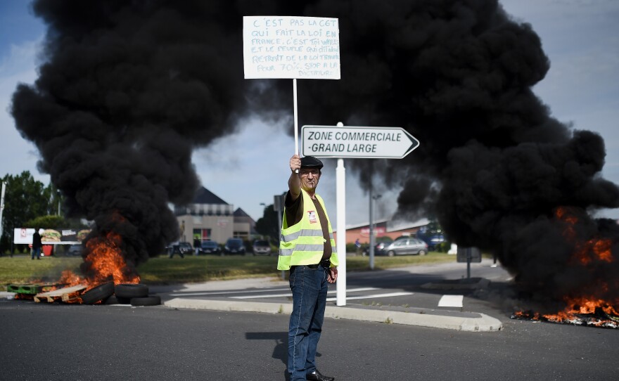 A protester holds a banner as people gather Thursday in Saint-Nazaire, in western France, to demonstrate against the government's proposed changes to labor law.