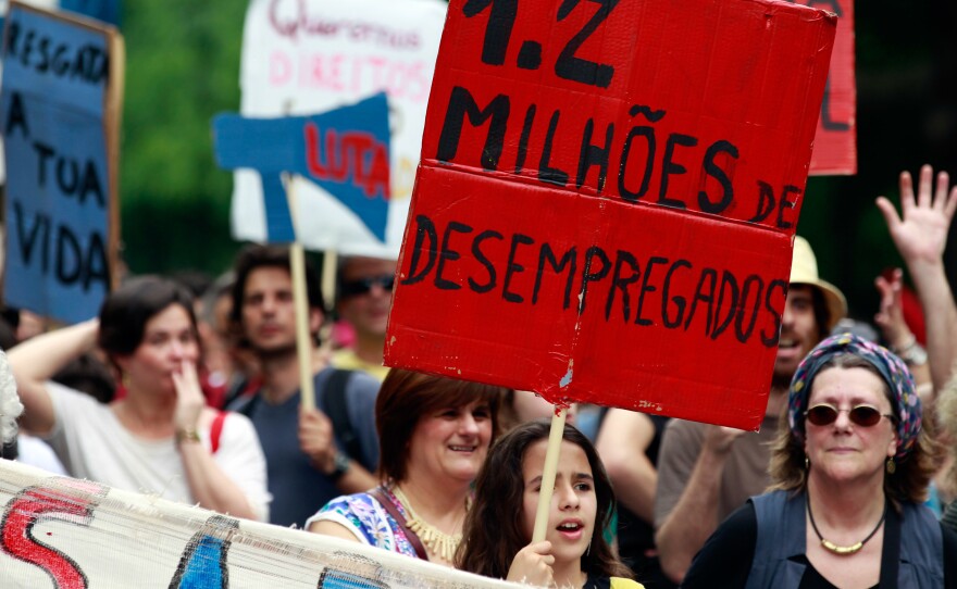 A young girl holds a sign with the words "1.2 Million Unemployed" during an anti-austerity protest in Lisbon on May 12, 2012.