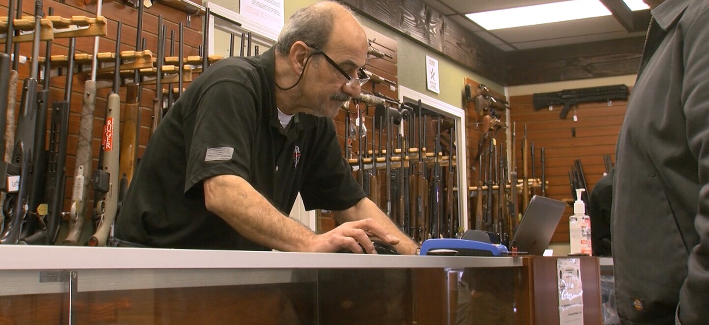 A customer looks at guns inside AO Sword Firearms in El Cajon, March 23, 2020.