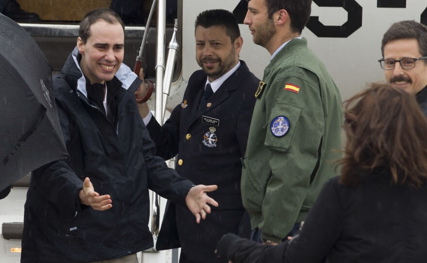 Spanish journalist Antonio Pampliega (left) arrives at the Torrejon military airbase in Madrid, Spain.