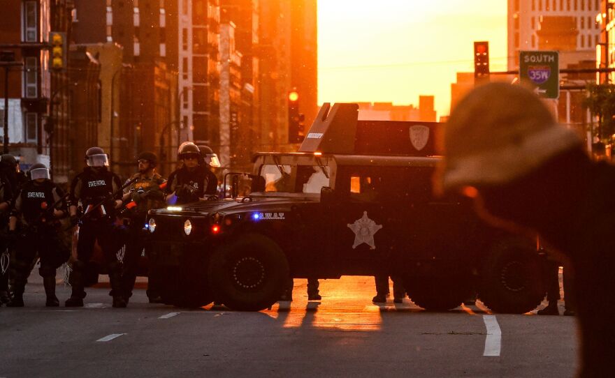 Police officers take guard during a protest over the death of George Floyd last month in Minneapolis.
