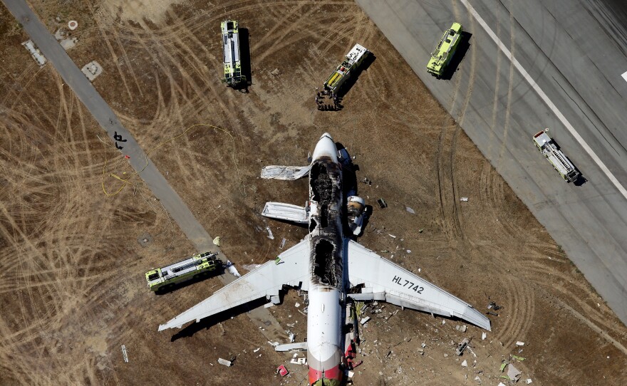 The remains of the plane lie burned on the runway after the crash.